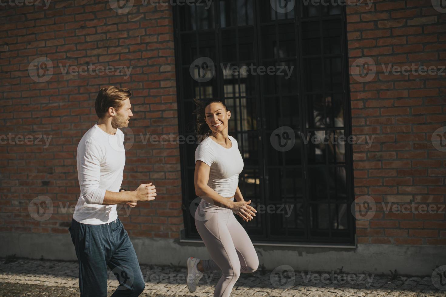 pareja joven corriendo en el entorno urbano foto