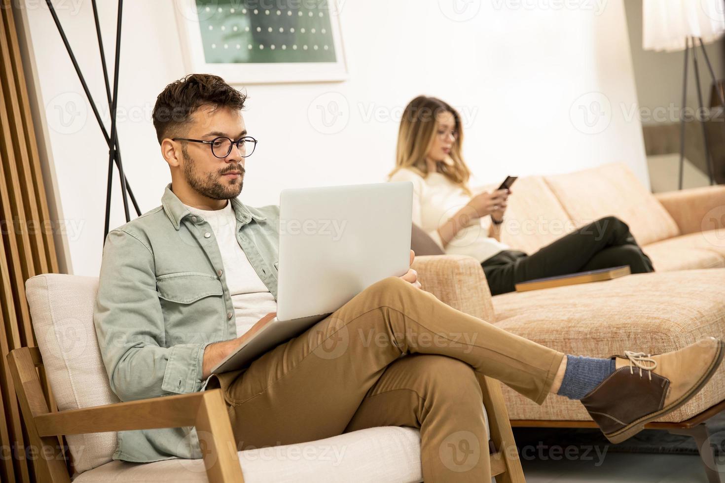 joven, usar la computadora portátil, en casa foto