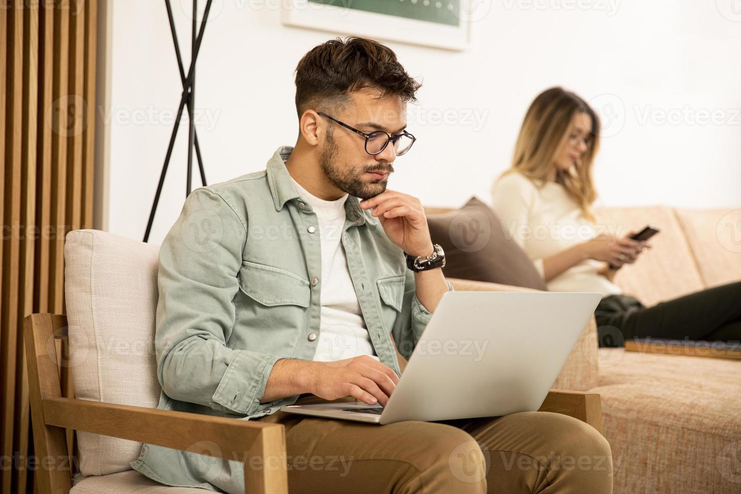 Young man using laptop at home photo