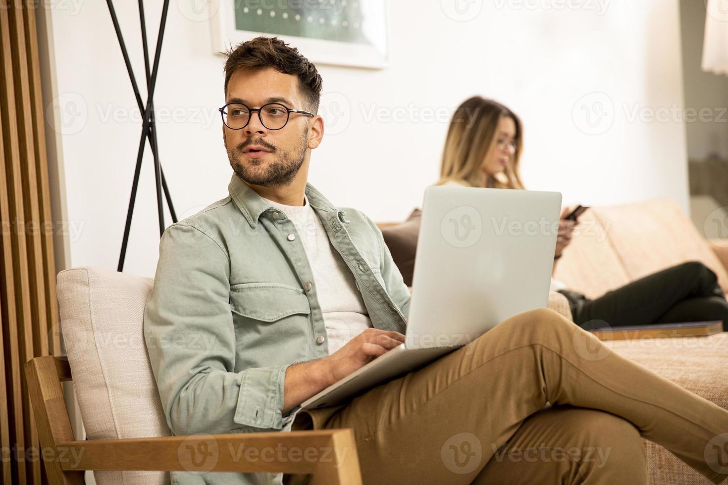 joven, usar la computadora portátil, en casa foto