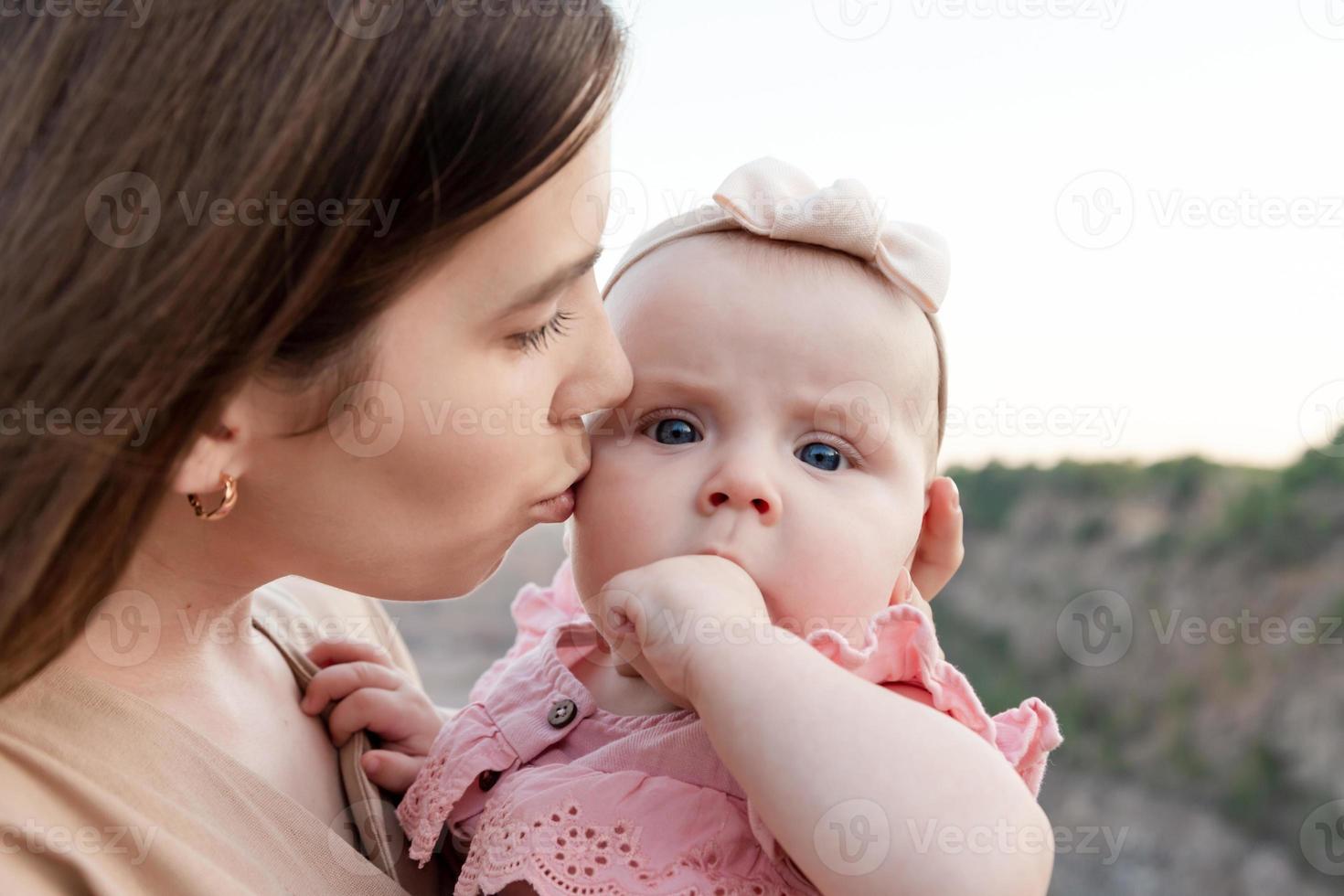 mamá sostiene a un niño en sus brazos foto