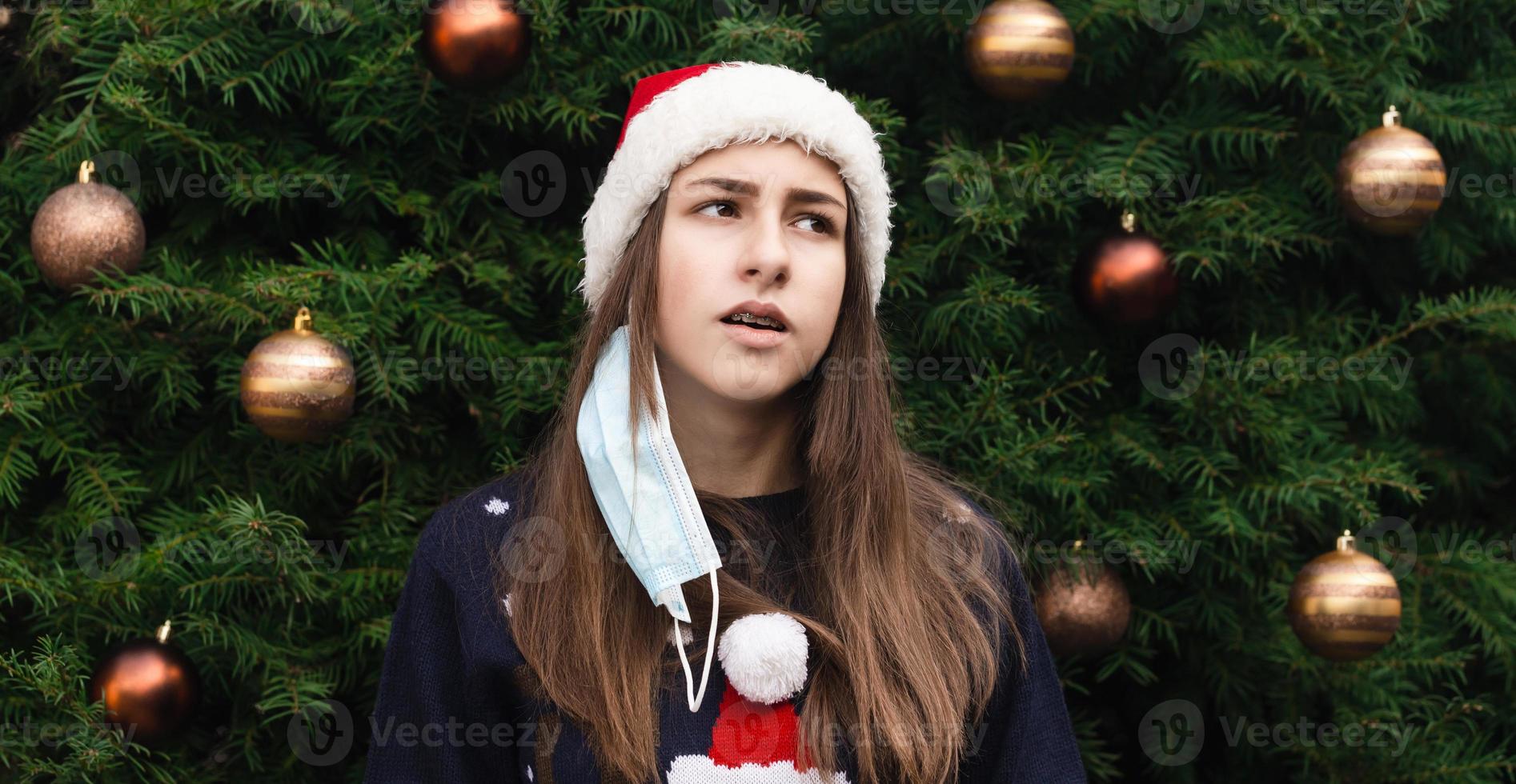 Teenage girl taking off a medical mask photo