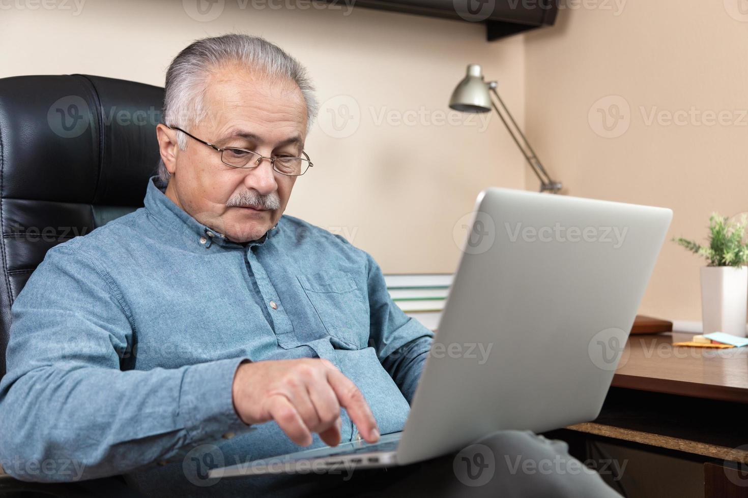 Senior man learns to use computer photo