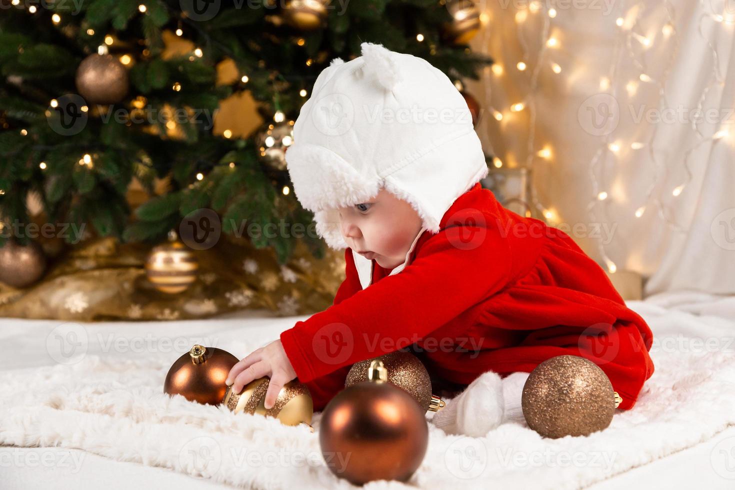 bebé sostiene bola de navidad foto