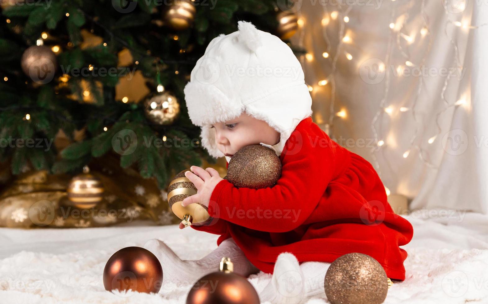 bebé sostiene bola de navidad foto