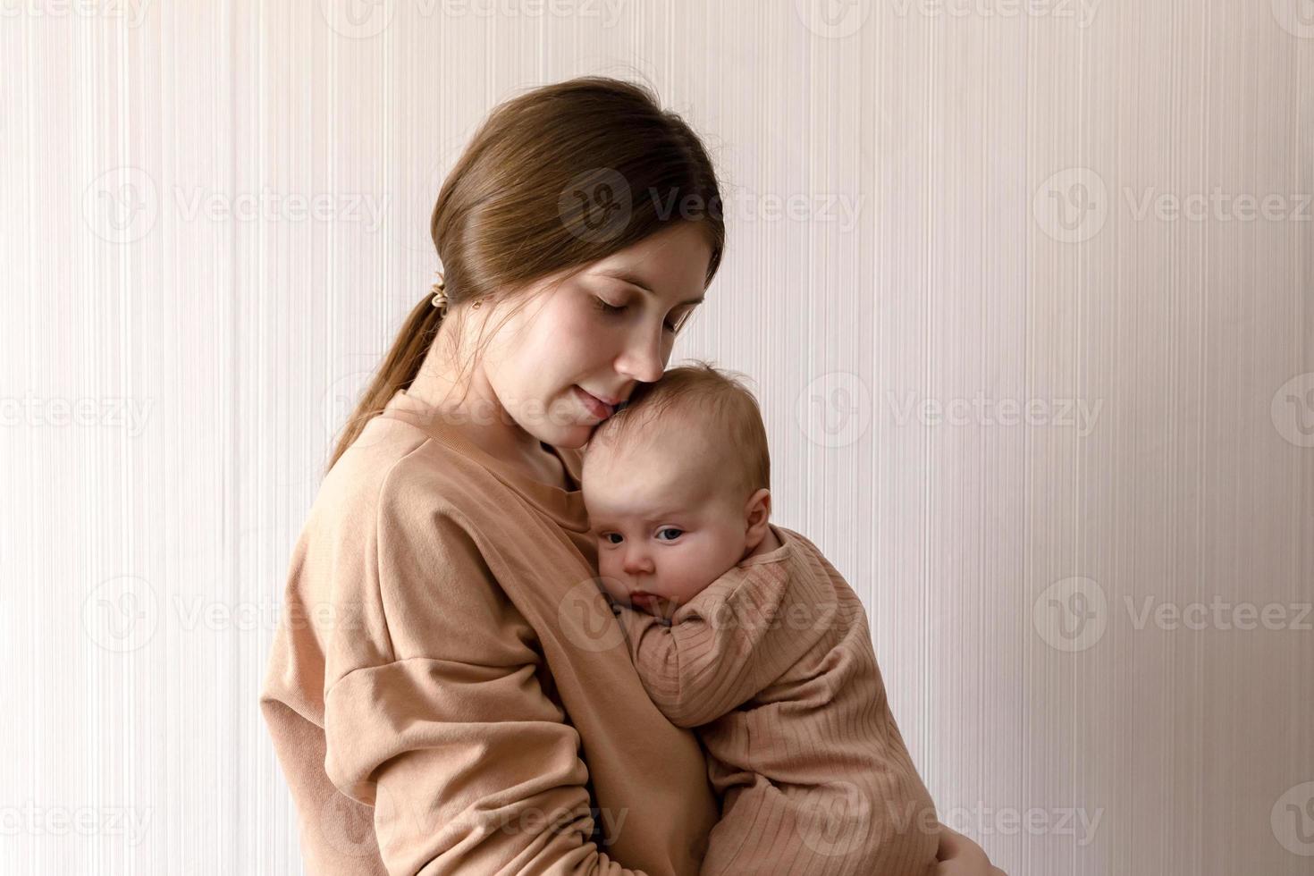 Alegre hermosa joven sosteniendo a una niña en sus manos foto