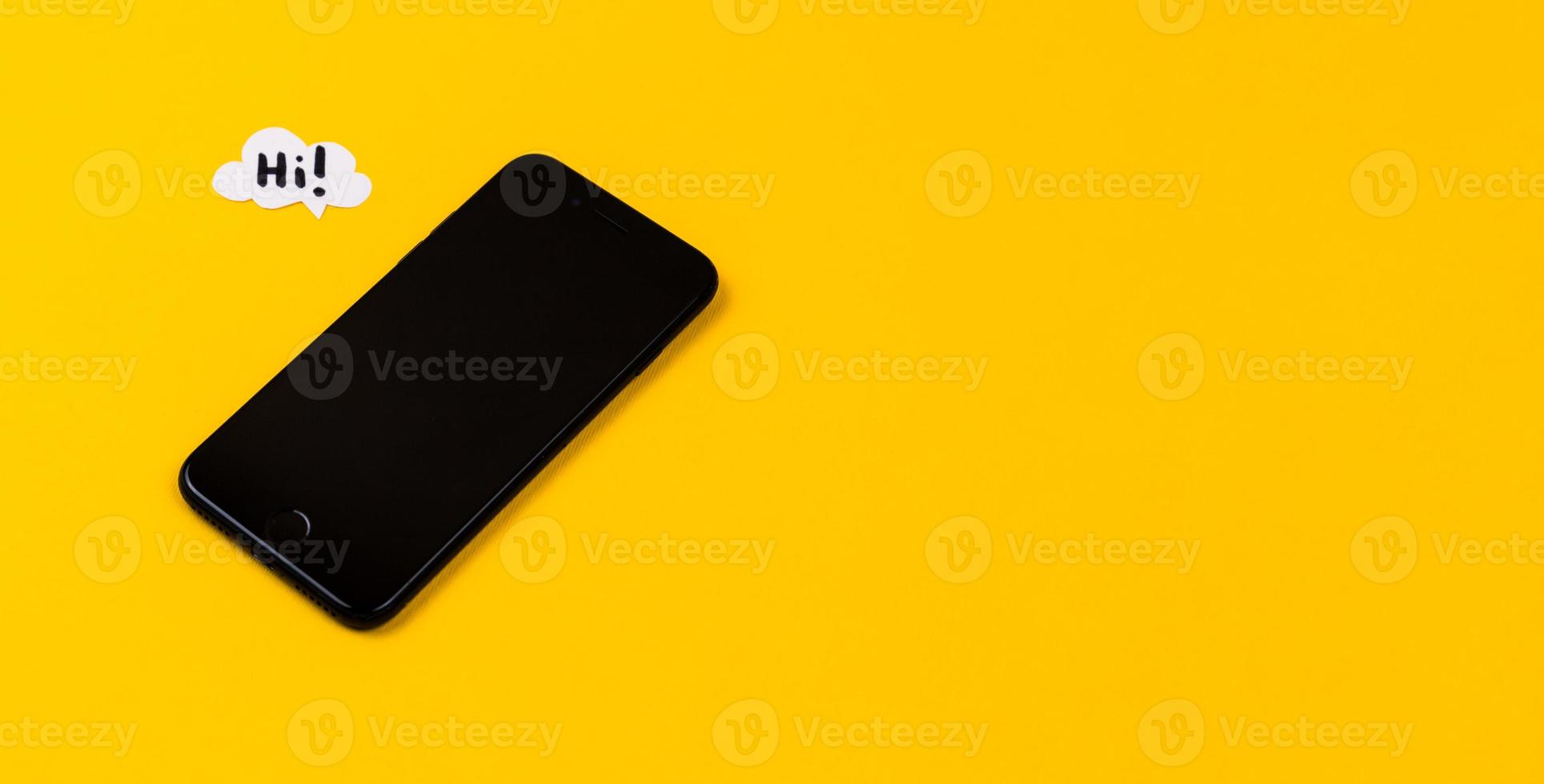 Smartphones with paper speech bubbles on yellow background photo