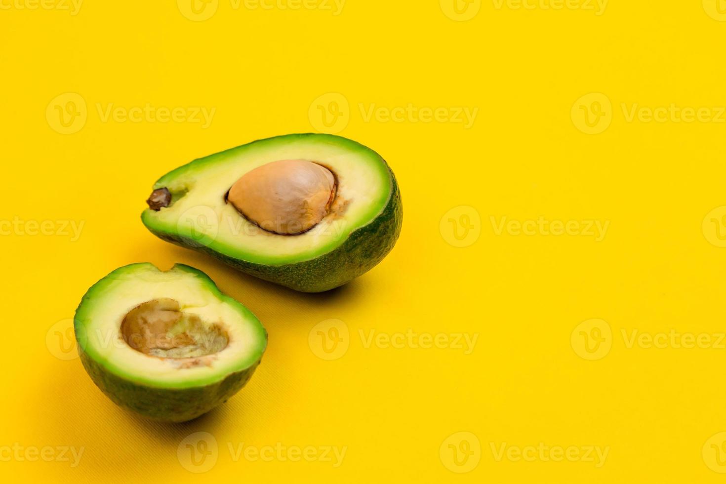 Cortar el aguacate maduro fresco sobre fondo amarillo foto