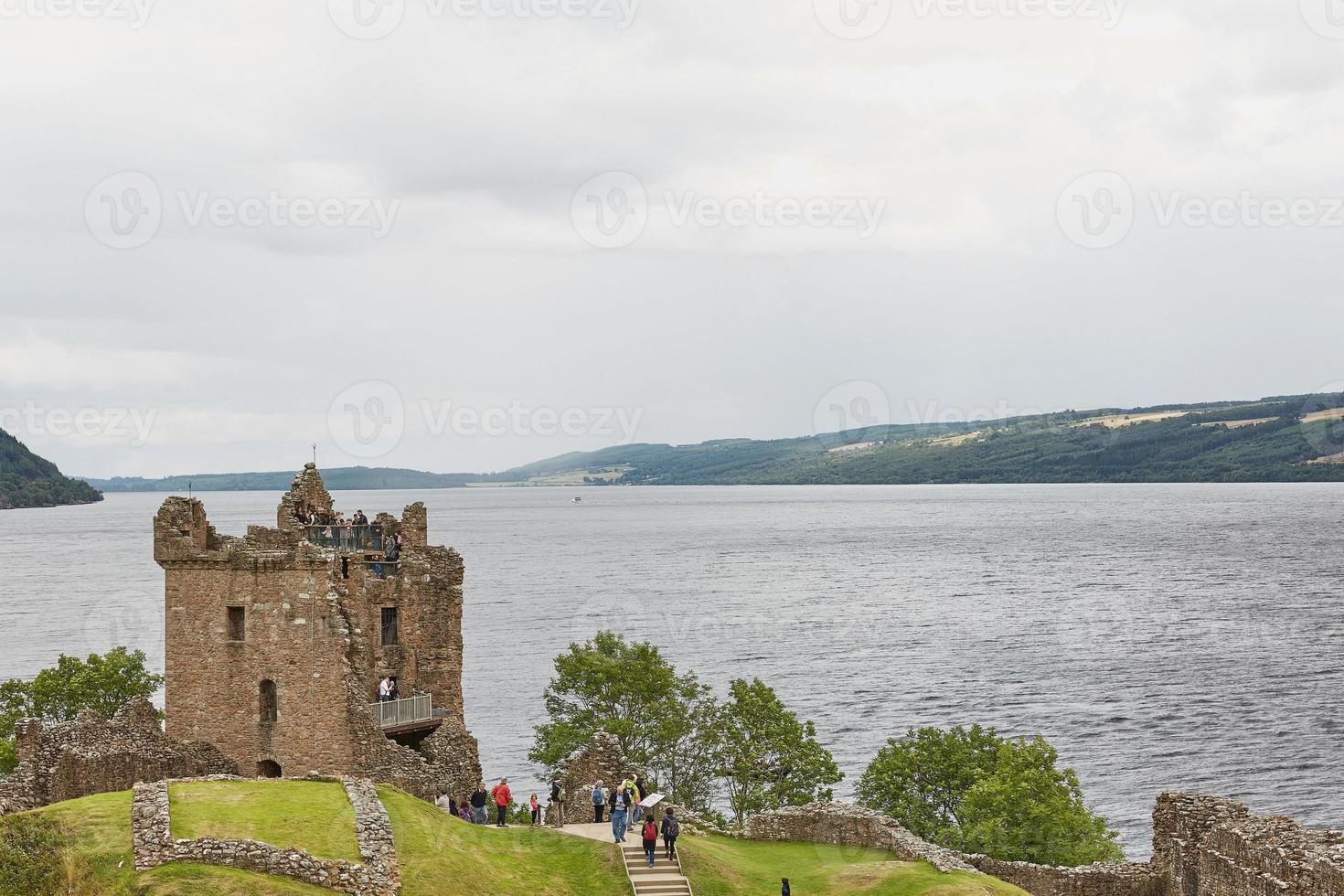 La gente en el castillo de Urquhart en la orilla del lago Ness, Escocia foto