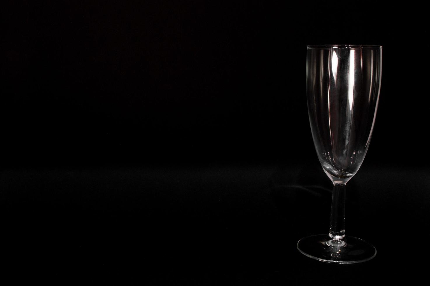 Empty champagne glass on black background photo