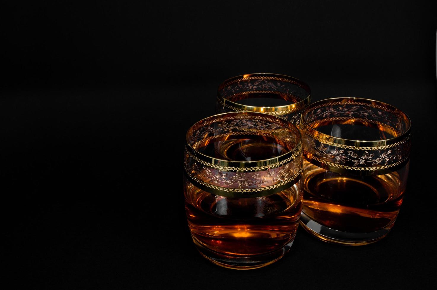Glass of dark red whiskey brandy or bourbon photo