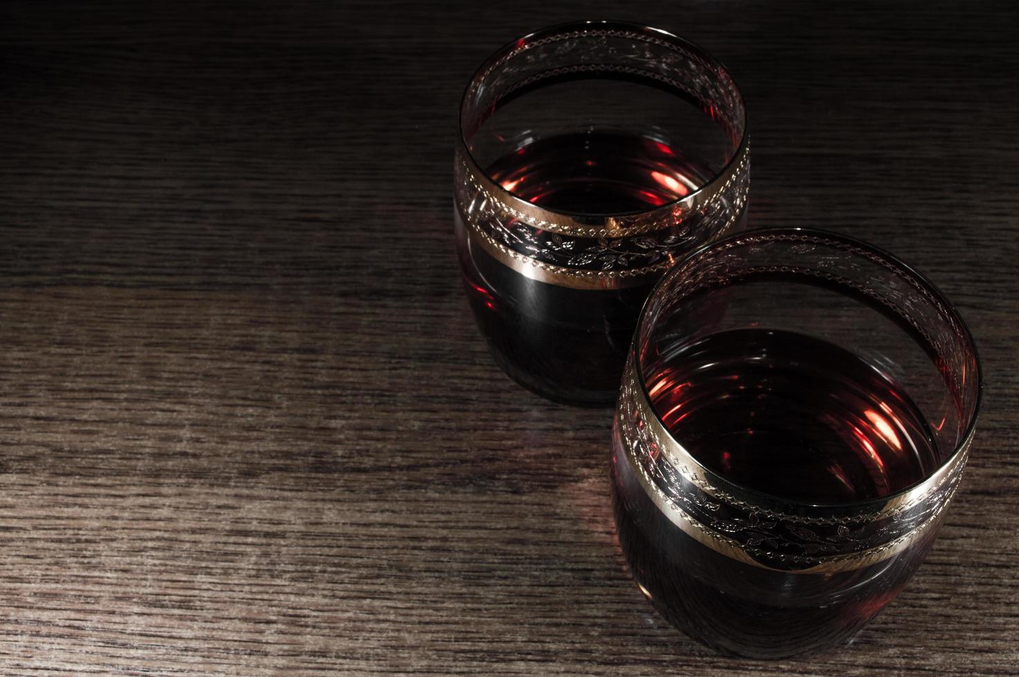 Glass of dark red whiskey brandy or bourbon photo