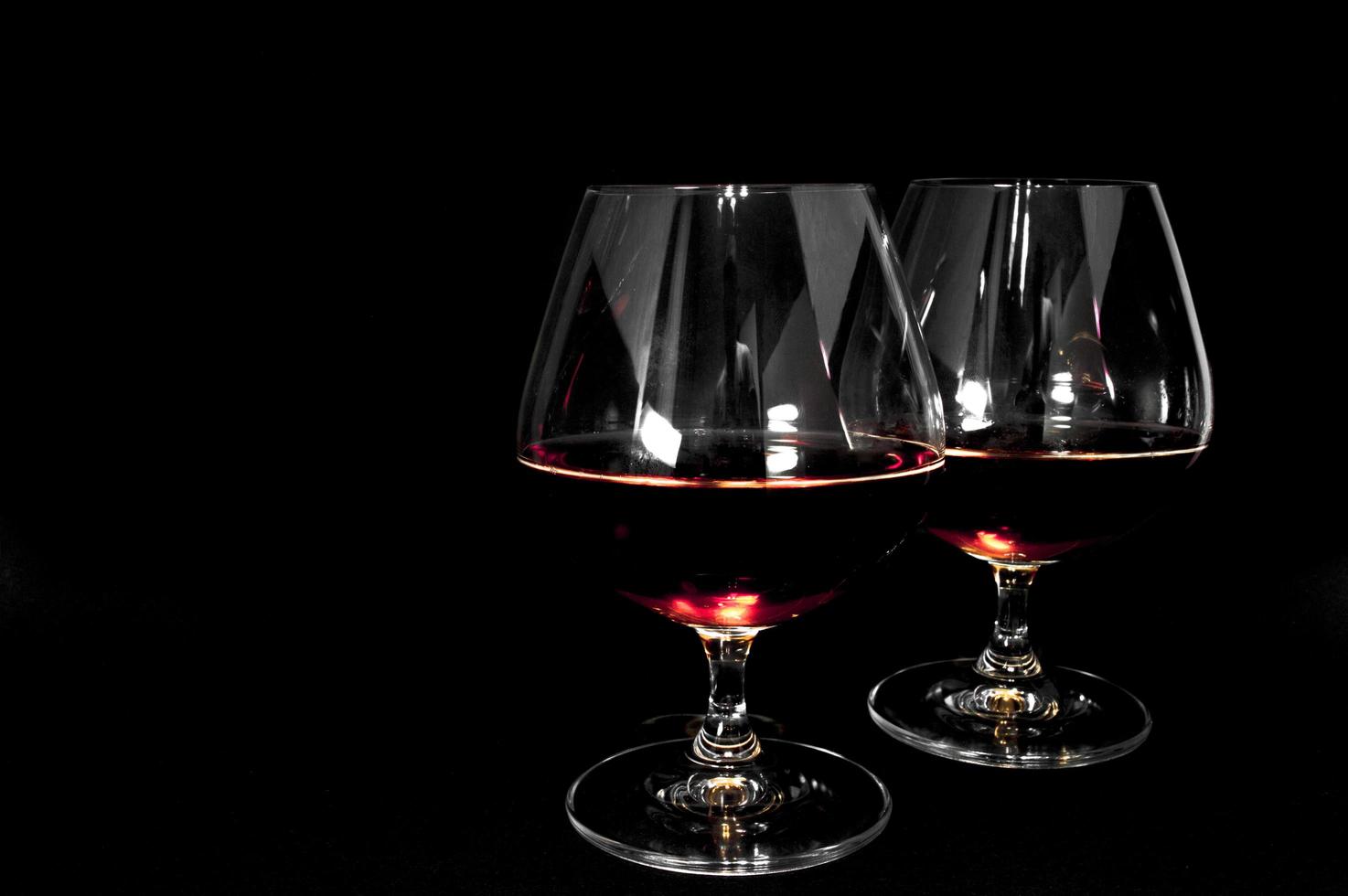 Glass of dark red brandy whiskey or bourbon photo