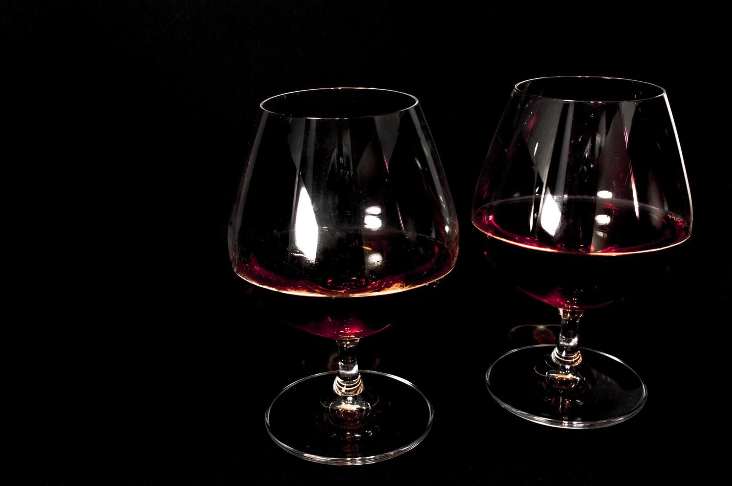 Glass of dark red brandy whiskey or bourbon photo