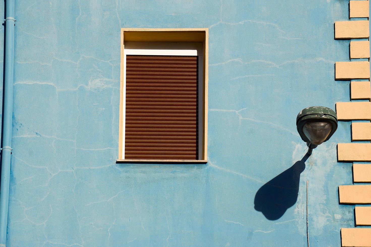 ventana en la fachada azul de la casa foto