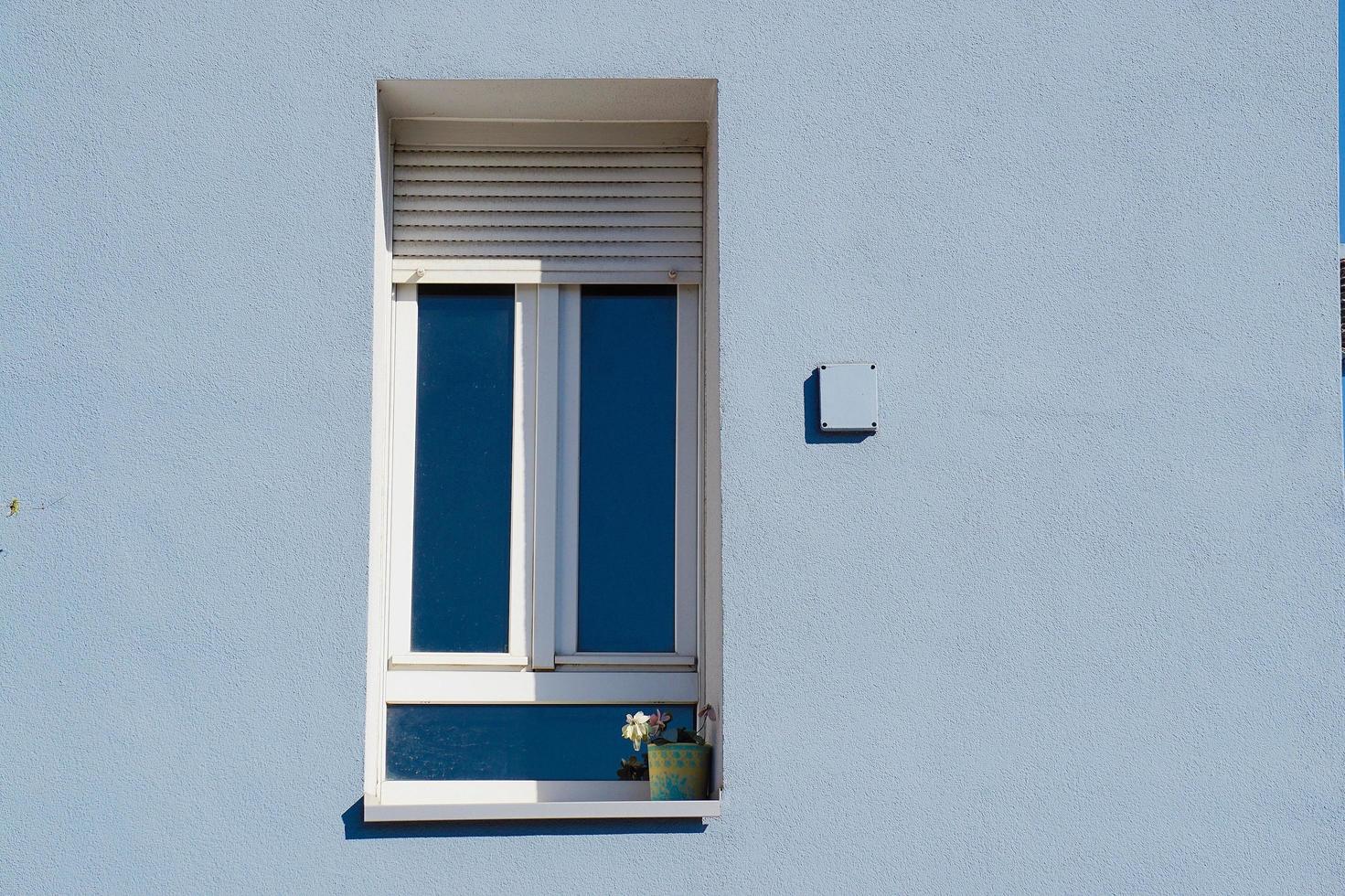 ventana en la fachada azul de la casa foto