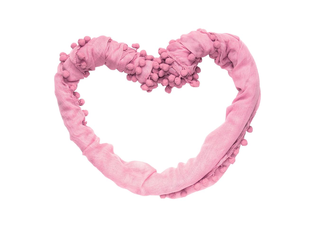 Frame in the shape of a heart of twisted pink fabric isolated on white background photo