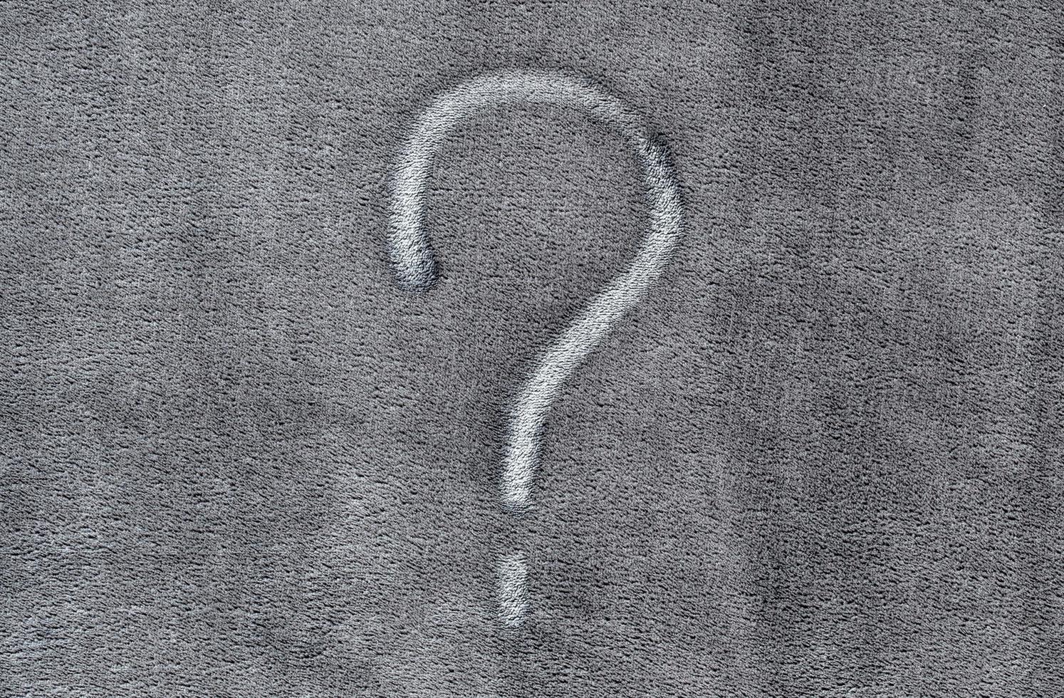 Question mark on gray fabric texture background photo