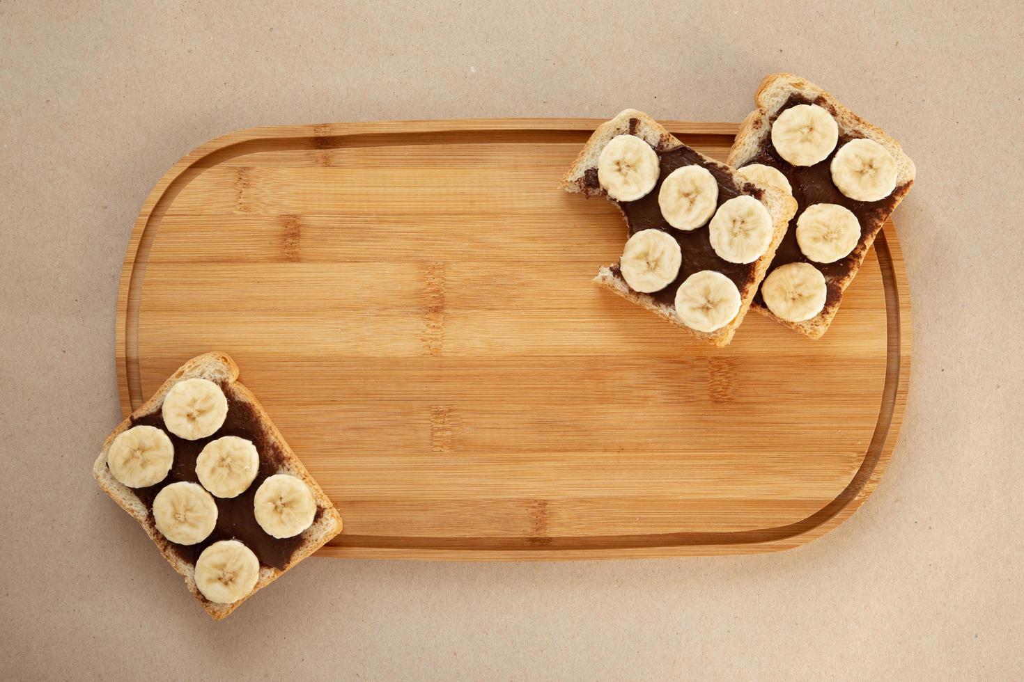 Three banana white bread toasts smeared with chocolate butter photo