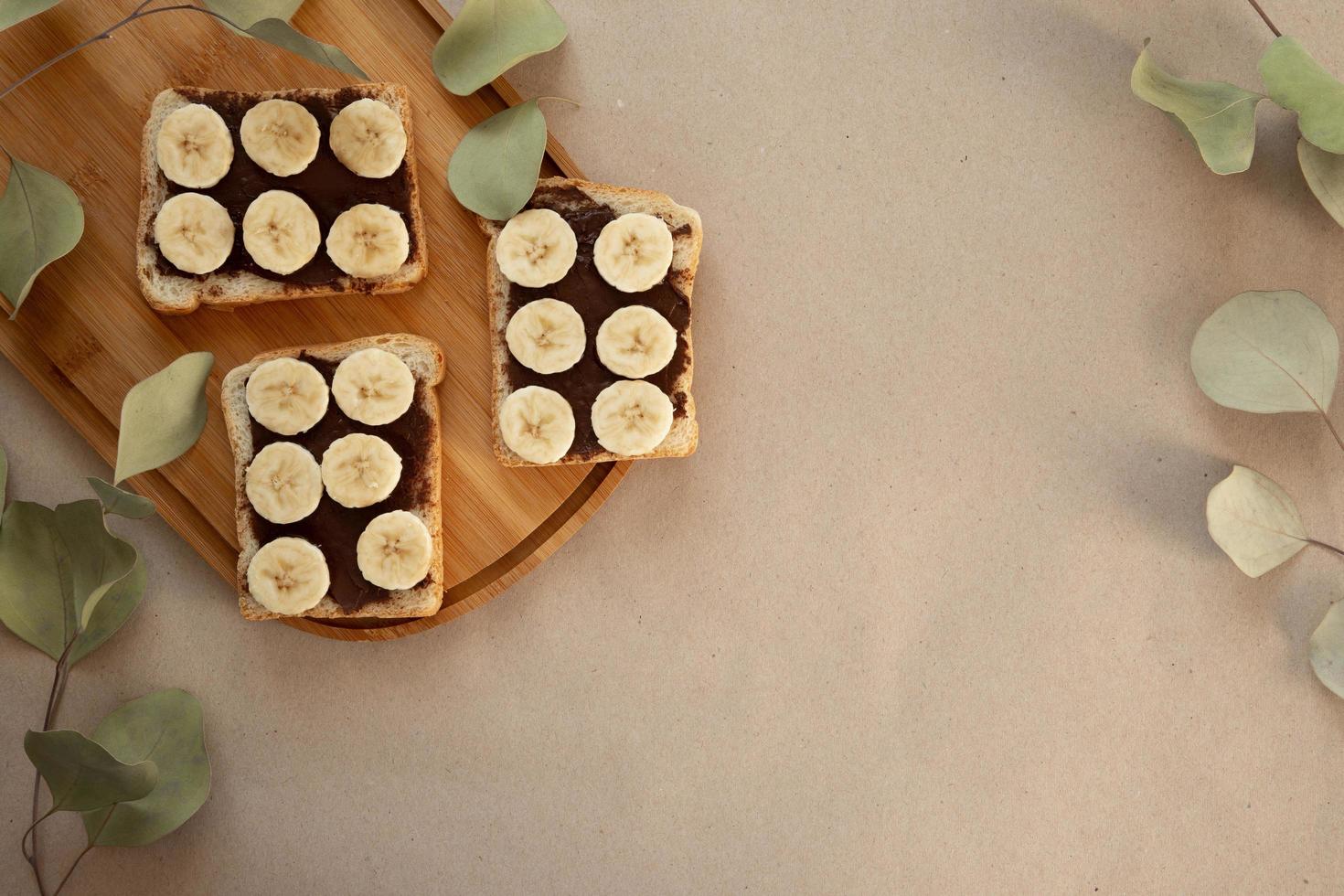 Three banana white bread toasts smeared with chocolate butter photo