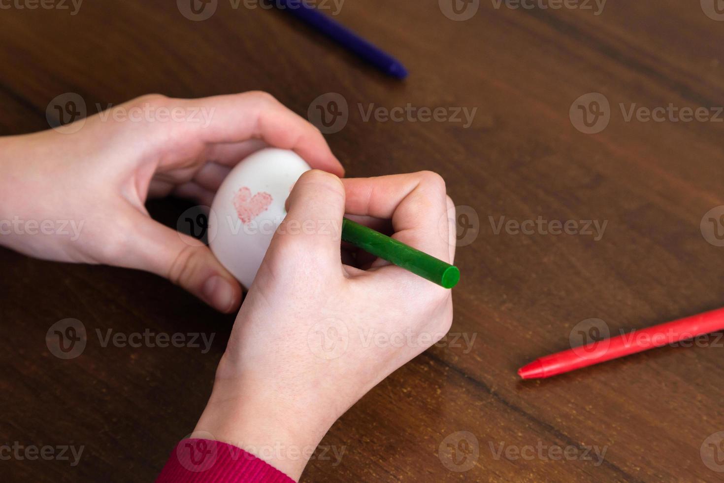 Close-up of woman hands coloring easter eggs with colors and brush photo