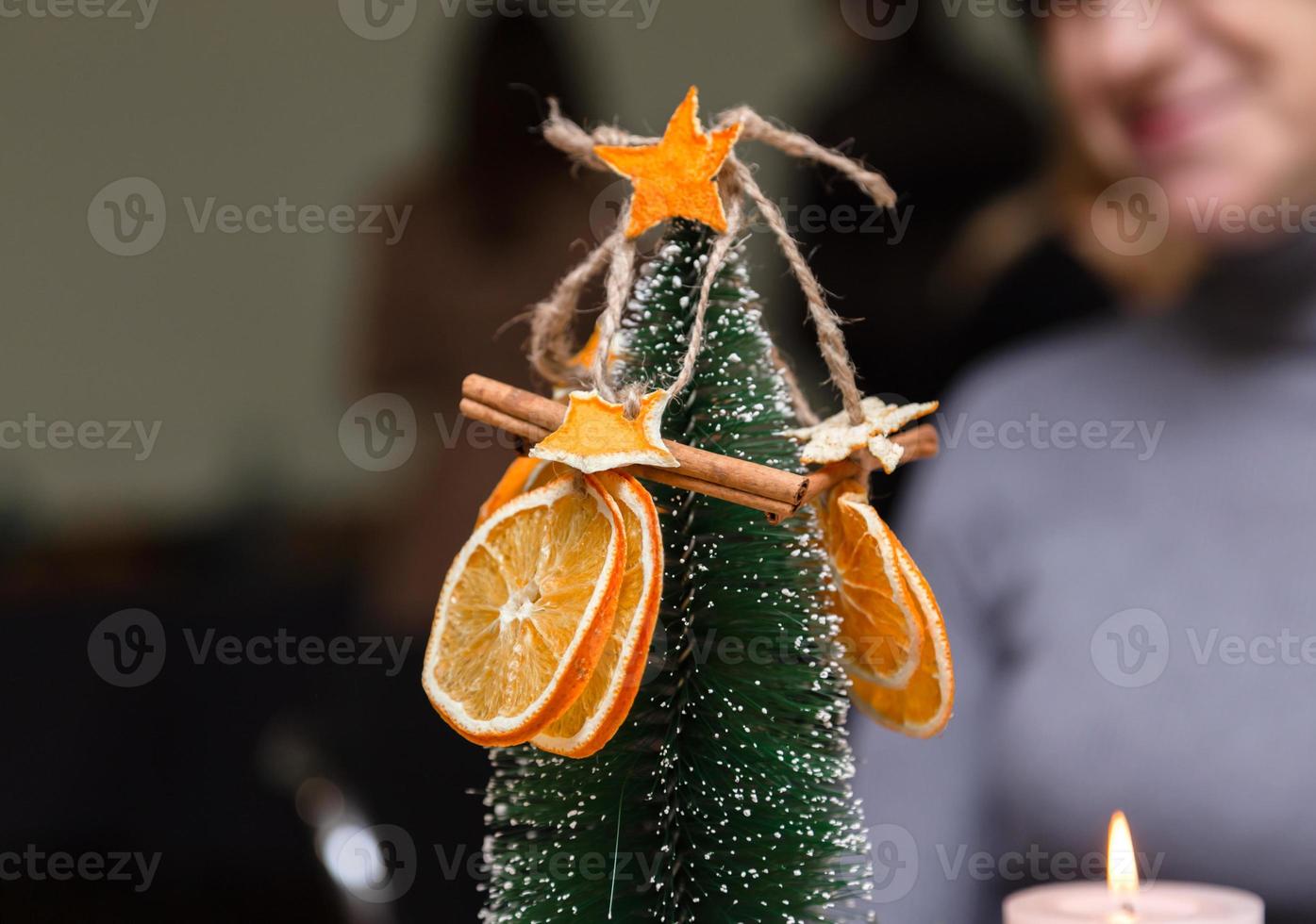 Dried orange stars from tangerine and cinnamon decoration hanging on a christmas tree photo