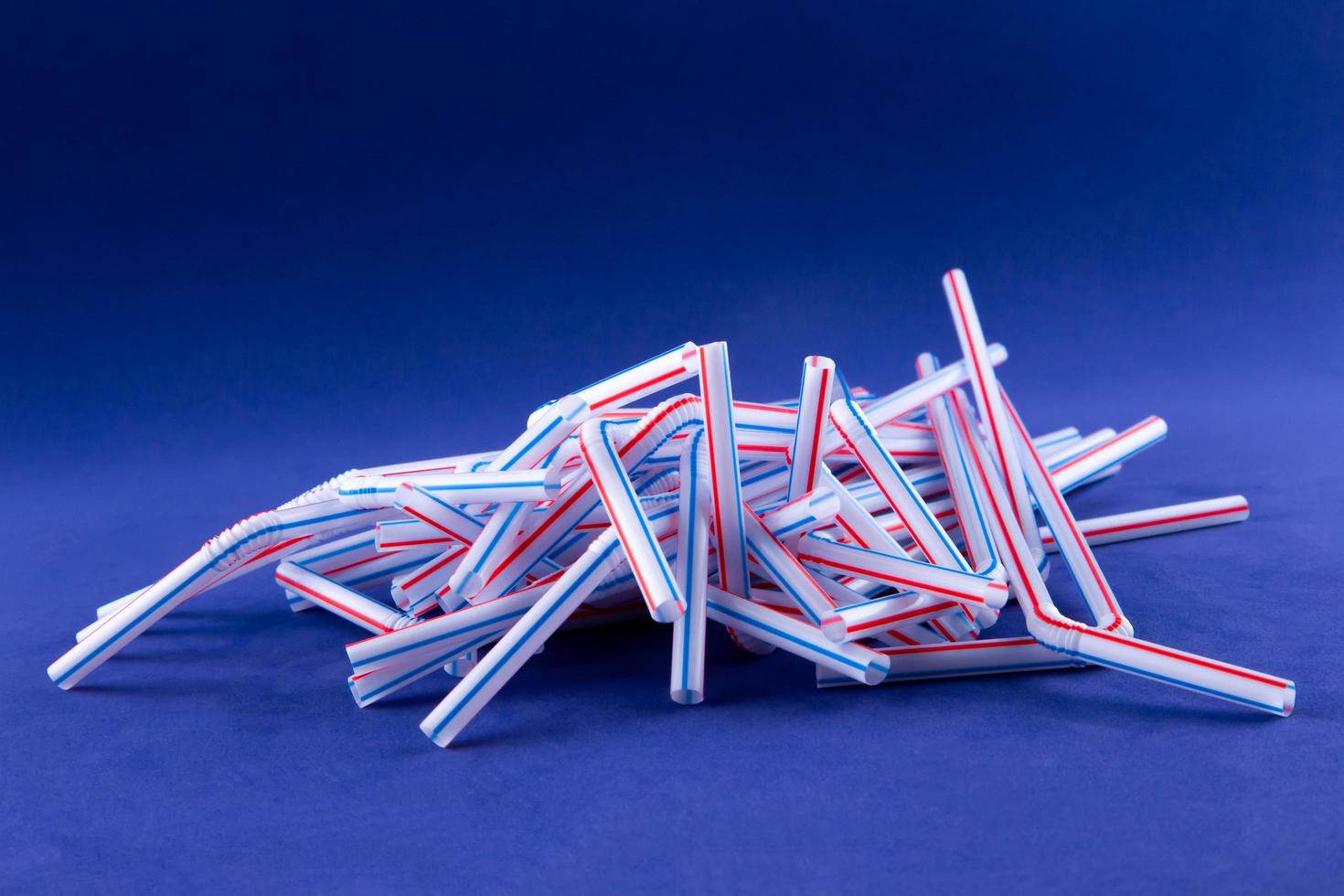 Coctail plastic tubes on blue purple background photo