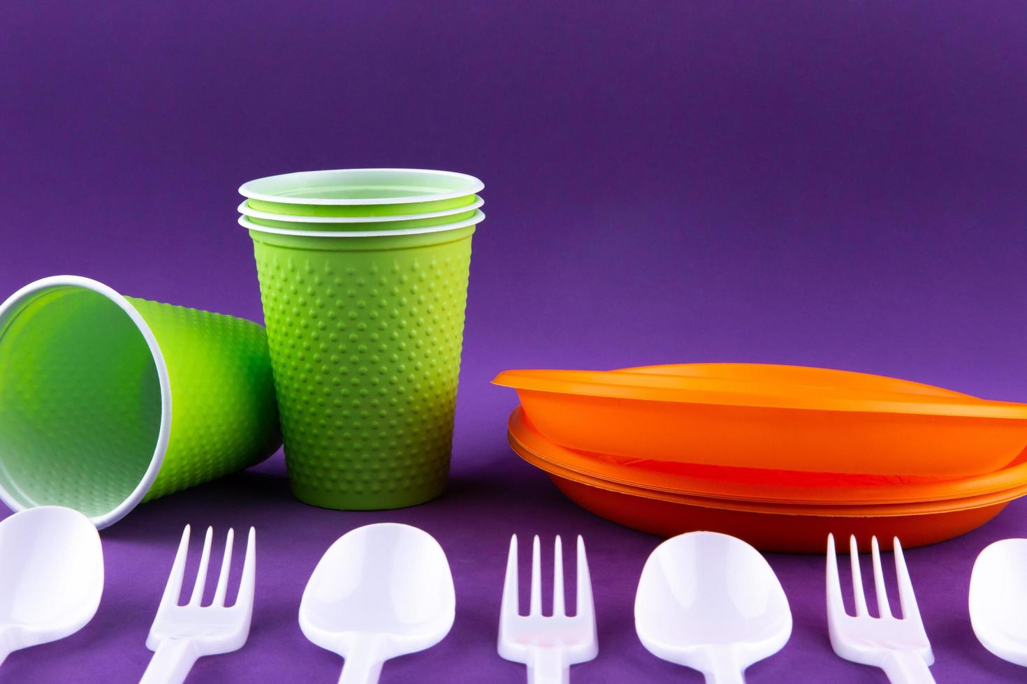 Plastic orange green waste collection on purple background photo
