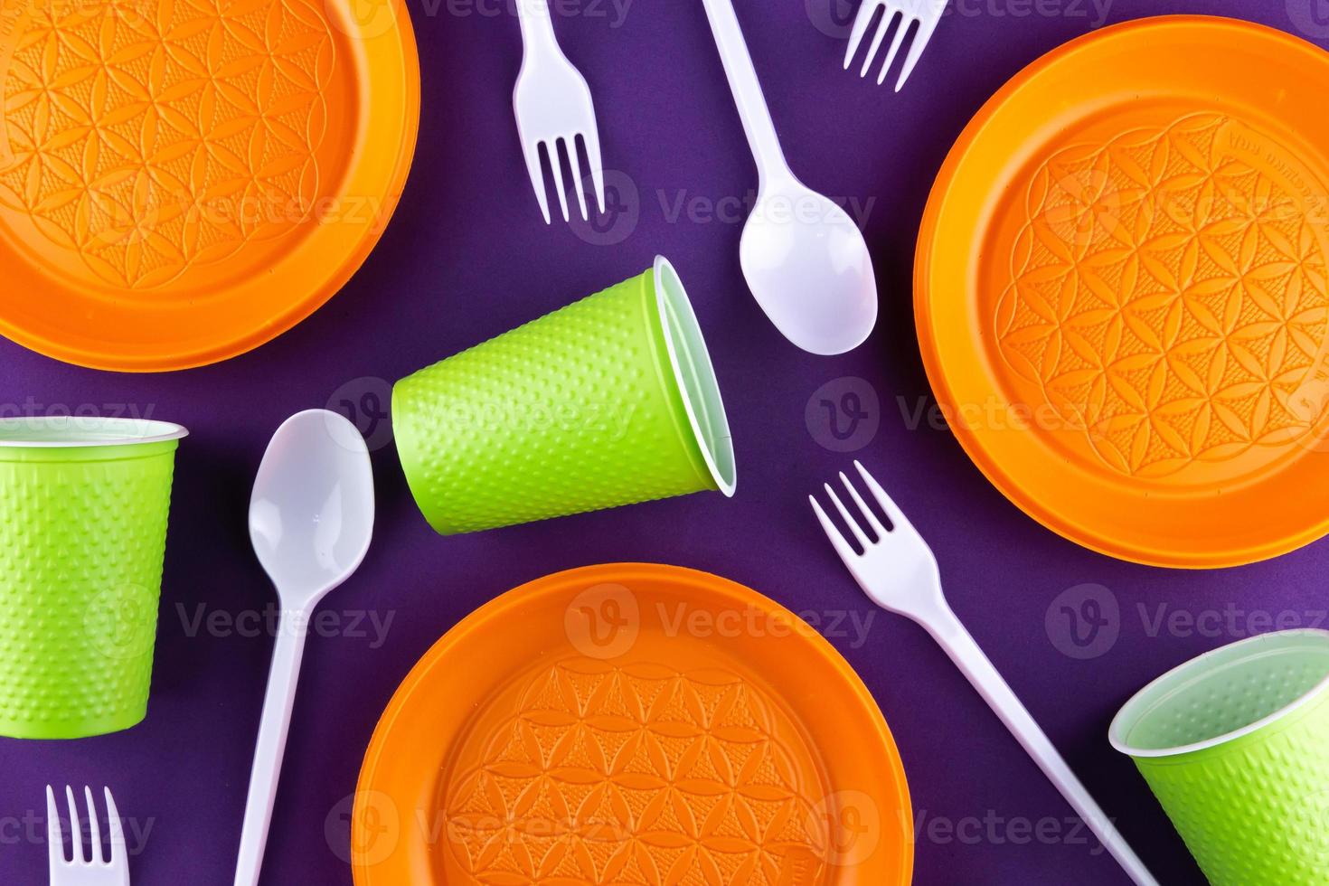 Recogida de residuos de plástico naranja verde sobre fondo púrpura foto