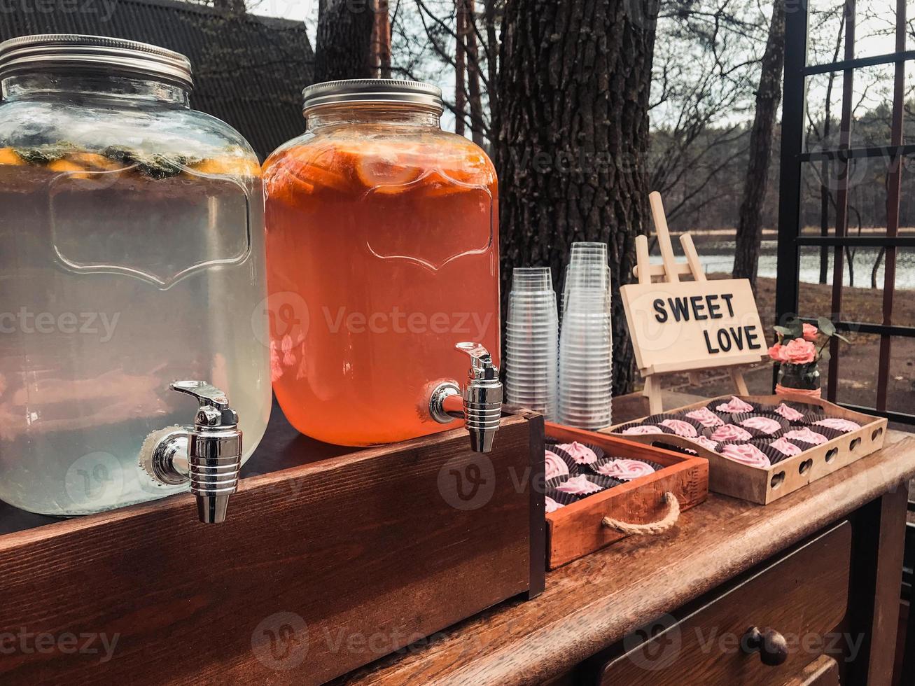 Location with summer drinks in glass jars or cupcake cans with a sign that says sweet love photo