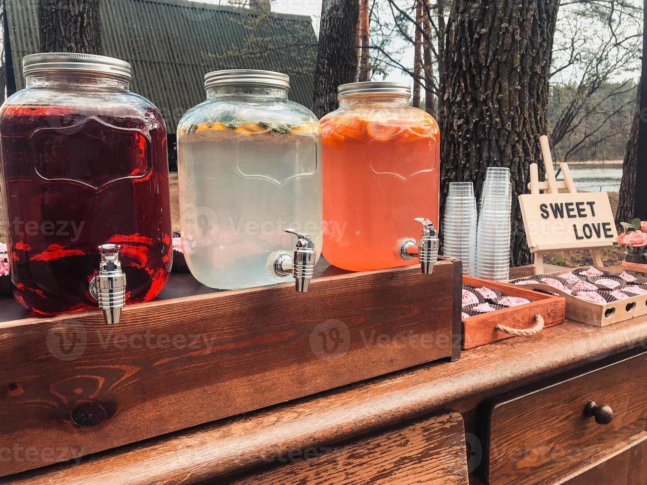 ubicación con bebidas de verano en frascos de vidrio o latas de cupcakes con un cartel que dice dulce amor foto