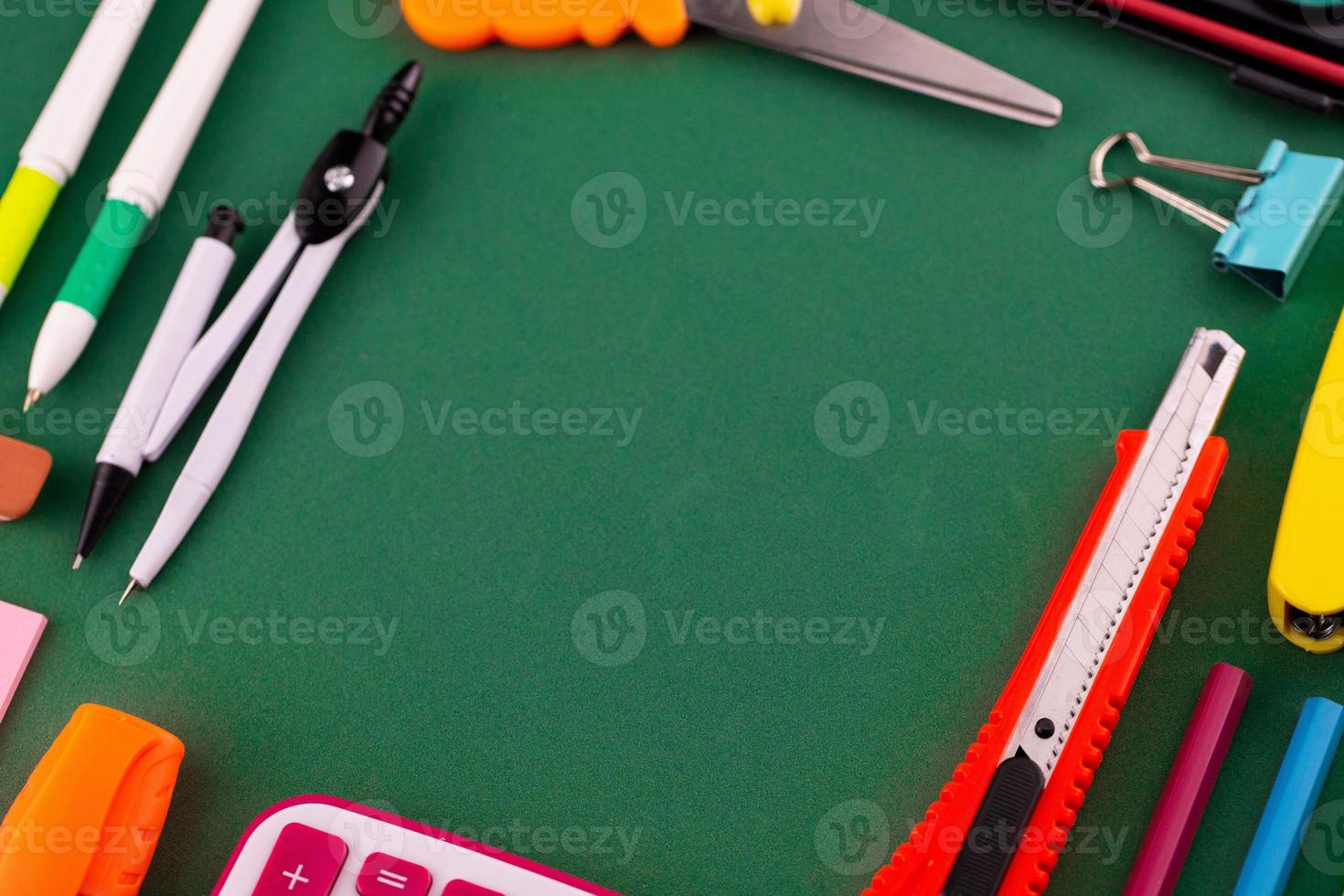 Material de oficina escolar papelería sobre un fondo verde escritorio con espacio de copia foto