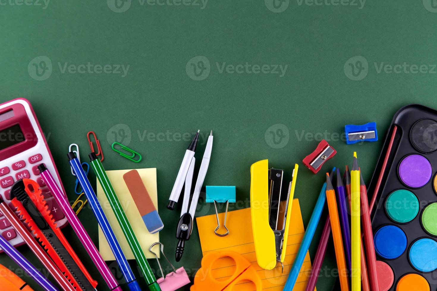 School office supplies stationery on a green background desk with copy space photo