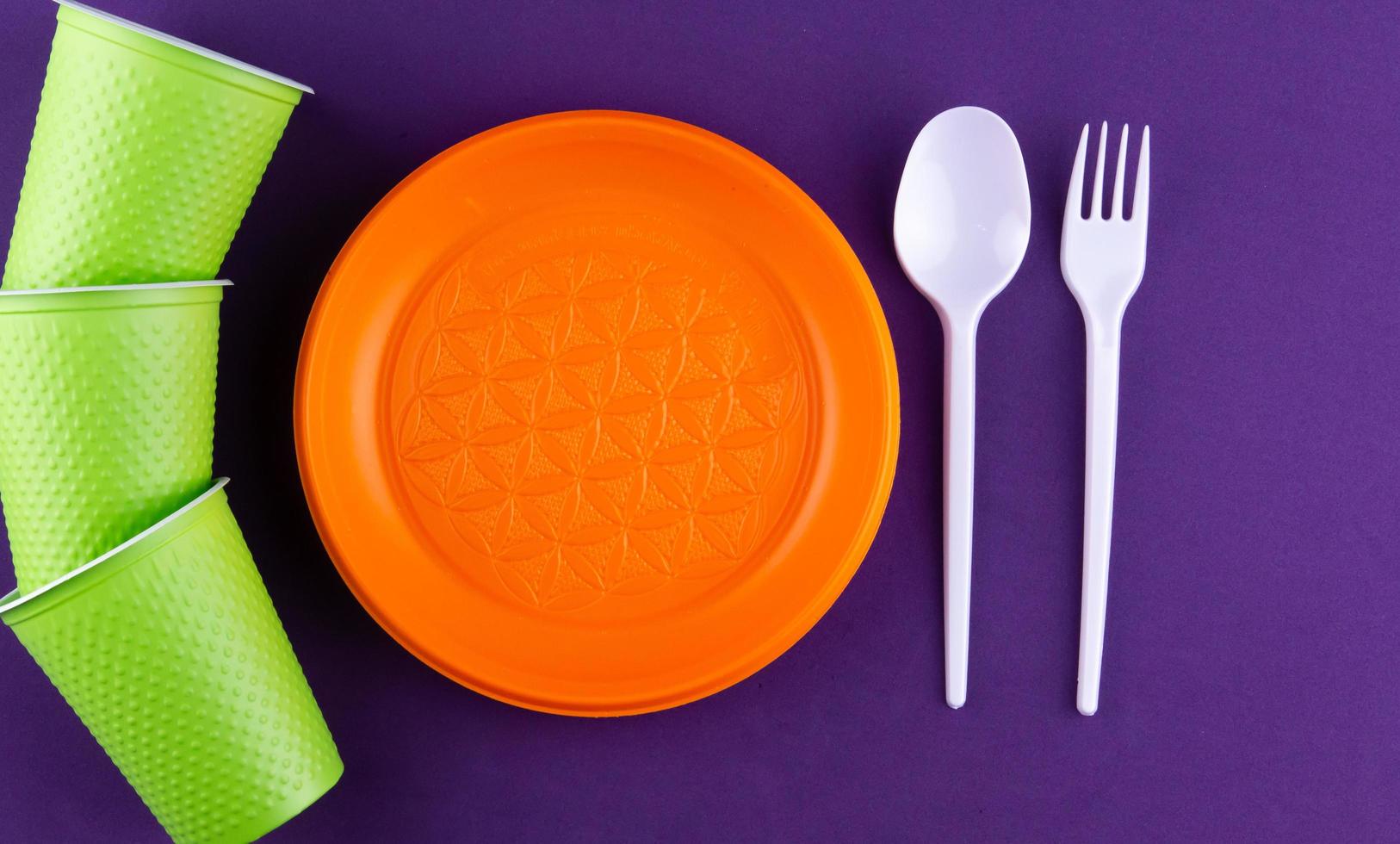 Plastic orange green waste collection on purple background photo
