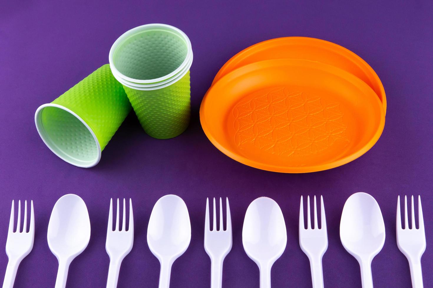 Plastic orange green waste collection on purple background photo