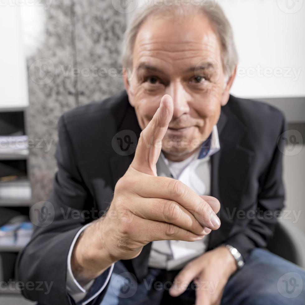 Middle aged man in a suit threatens his finger photo