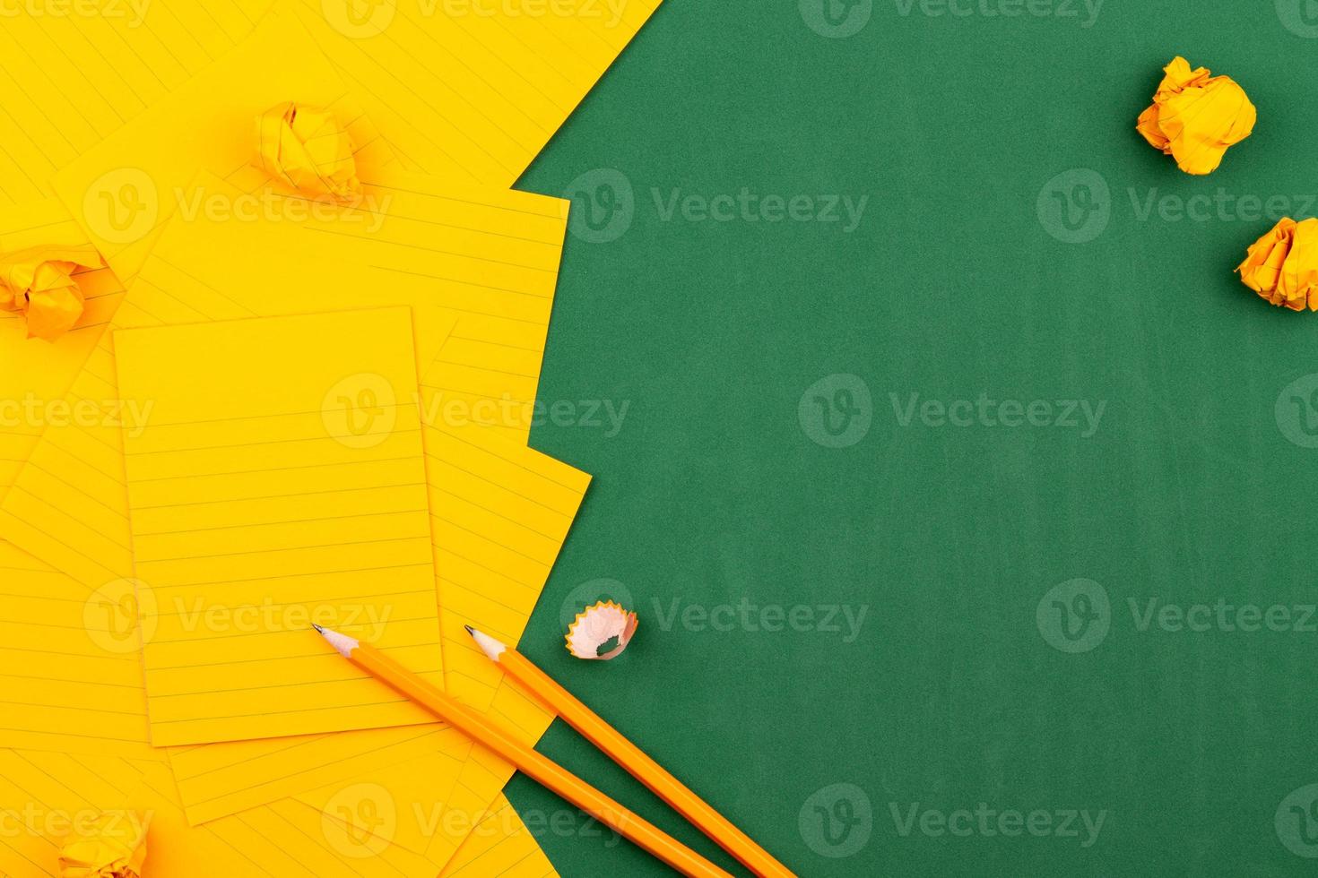 Orange sheets of paper on a green school board with a frame for text photo