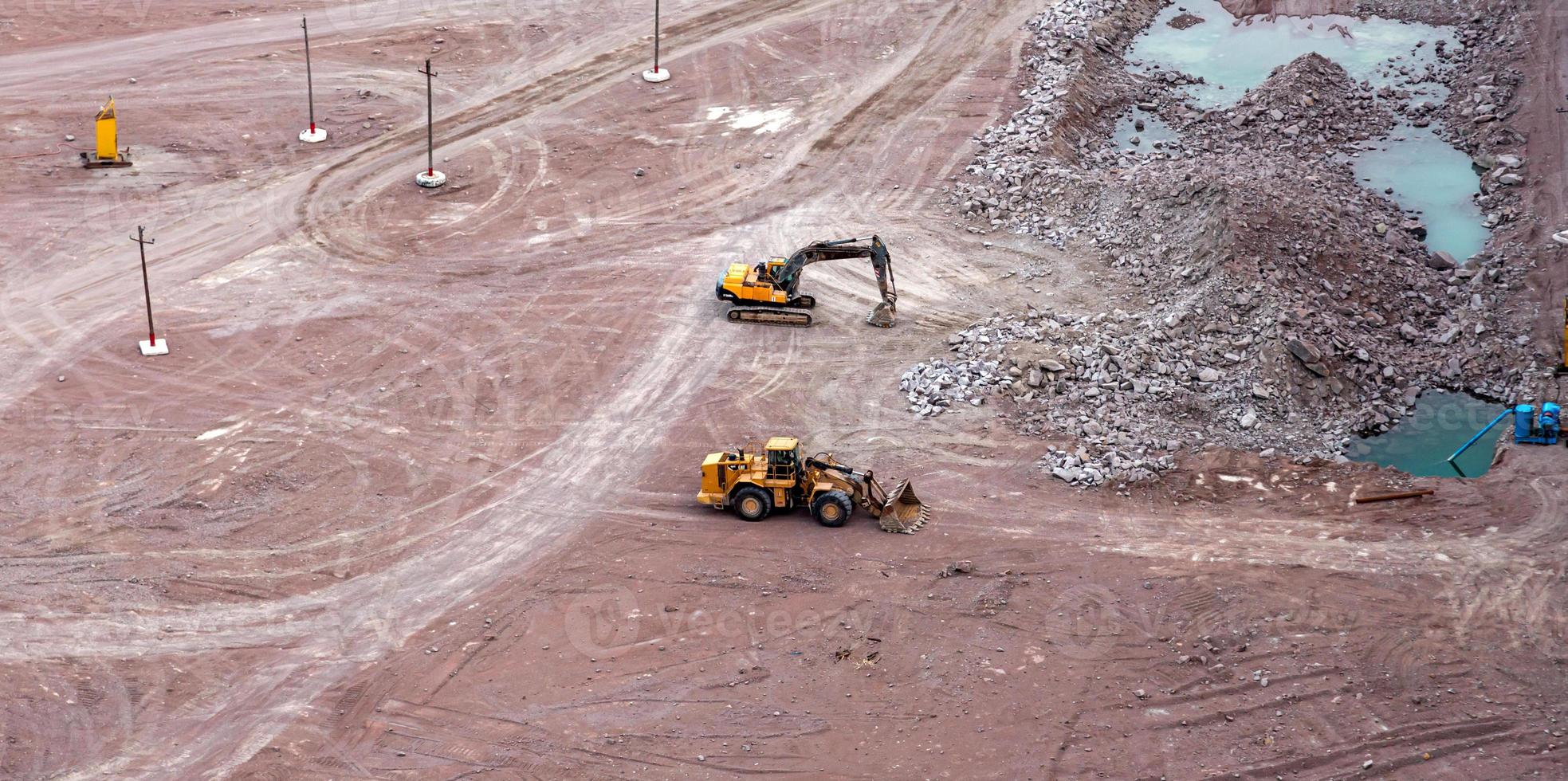 Excavator in a quarry extracting and moving stone photo