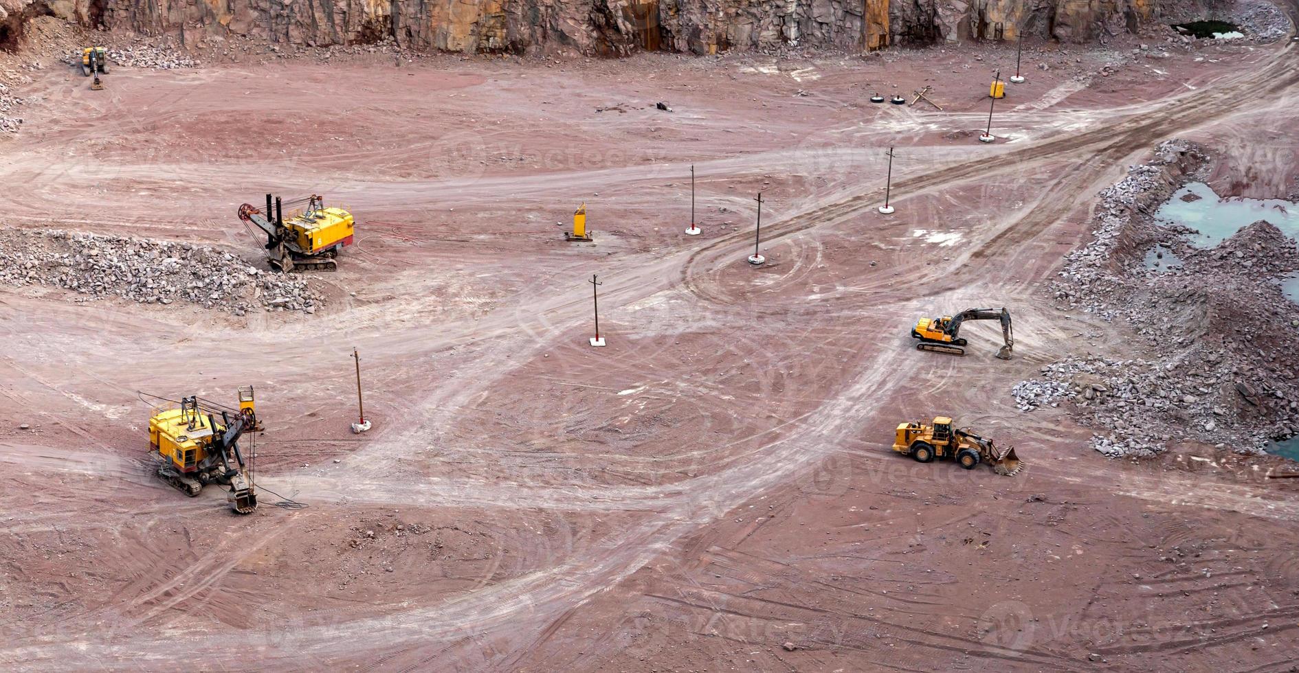 Excavator in a quarry extracting and moving stone photo