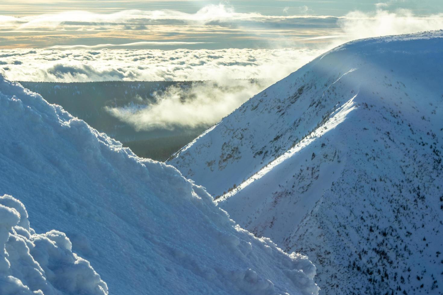 Snow mountains on sunny sky photo