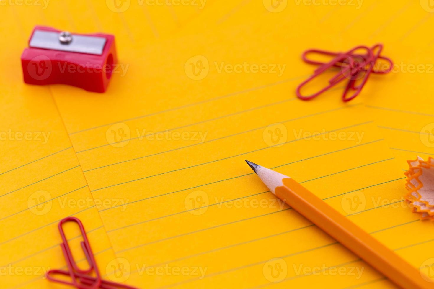 Orange sheets of paper pencil stationery and empty space for your text photo