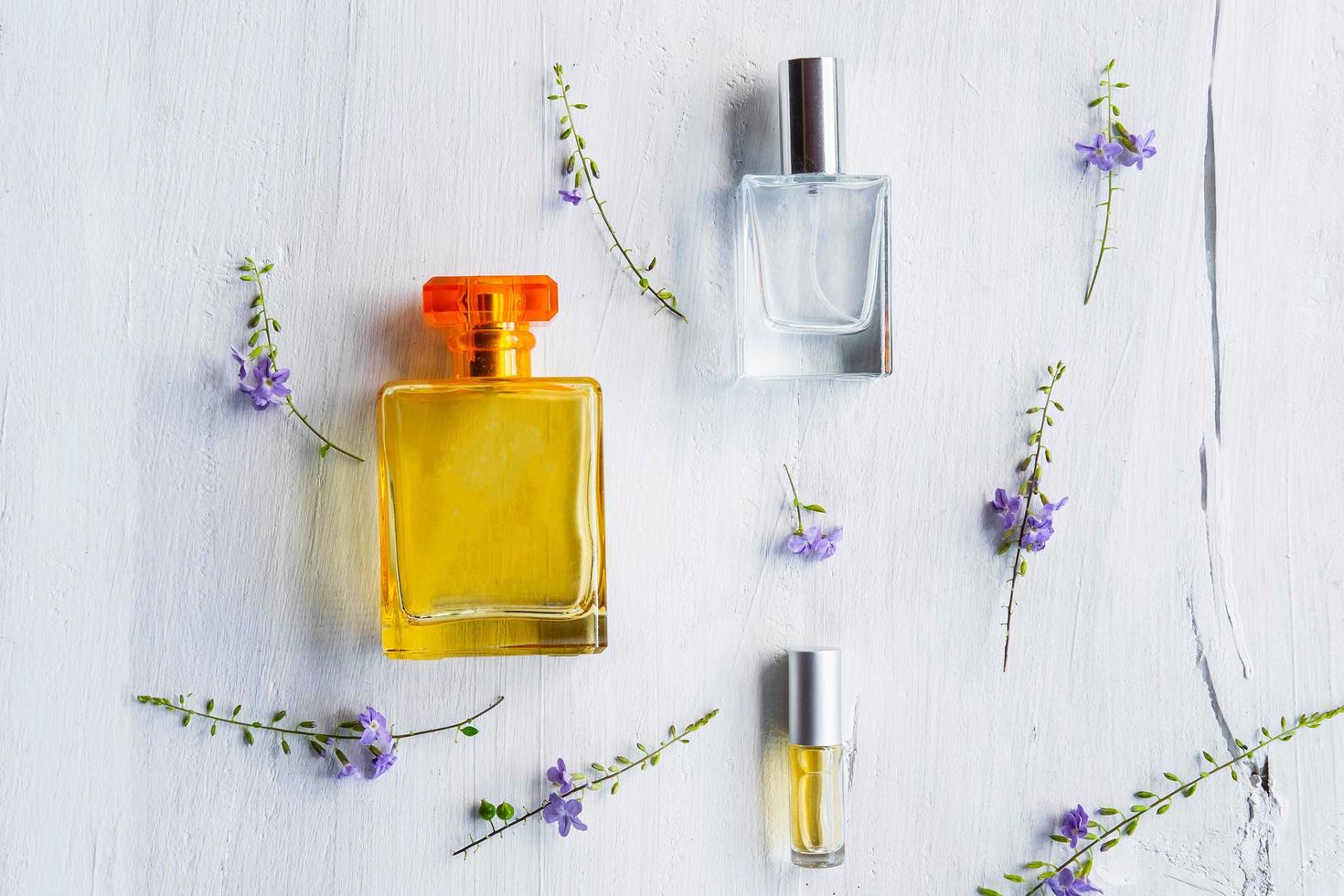 Perfumes and perfume bottles on a white wooden background photo