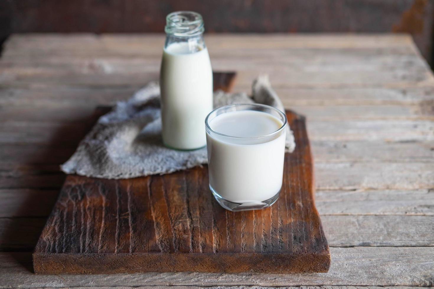 Bottles and milk glasses on a wooden table photo