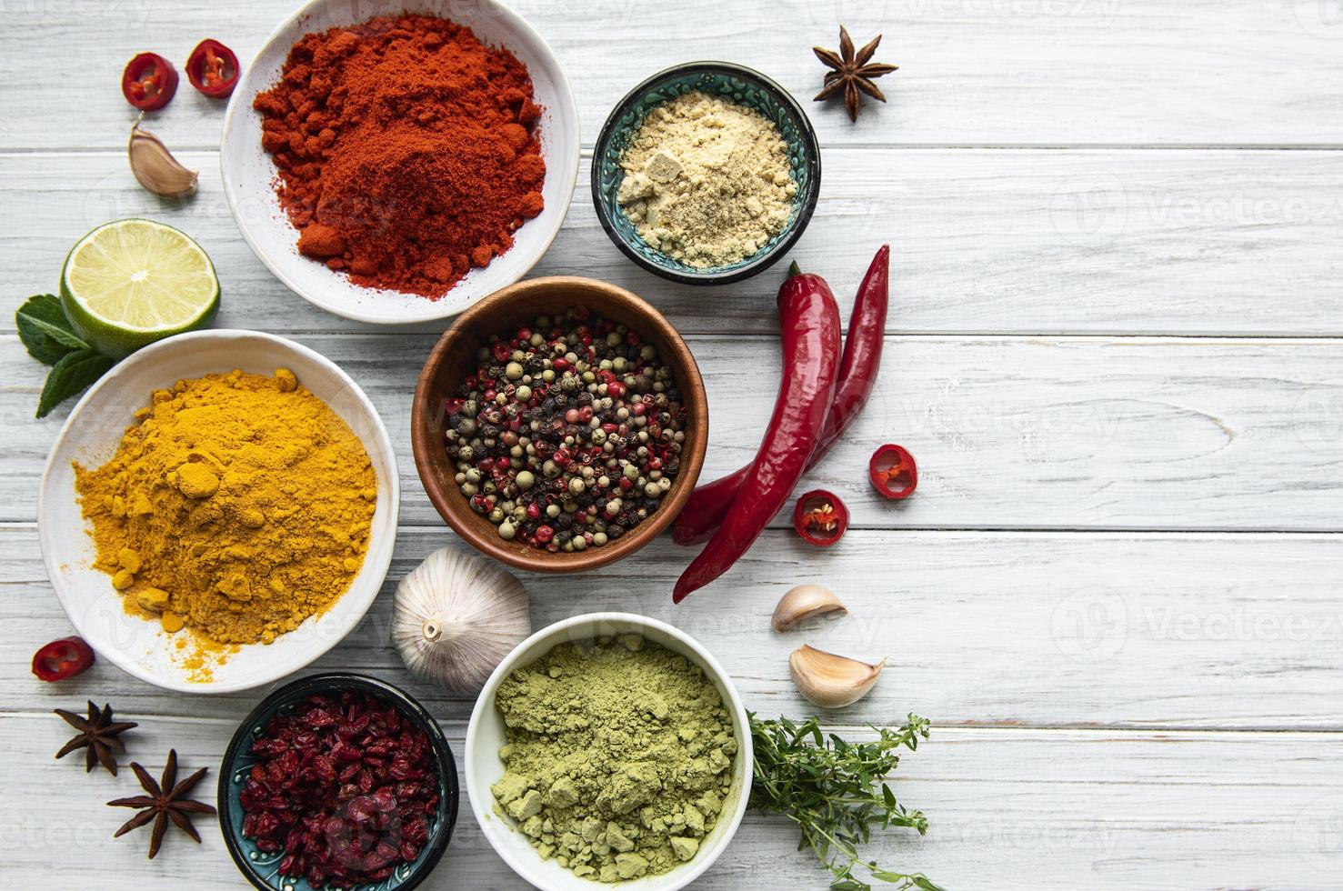 Various spices  on white wooden background top view photo