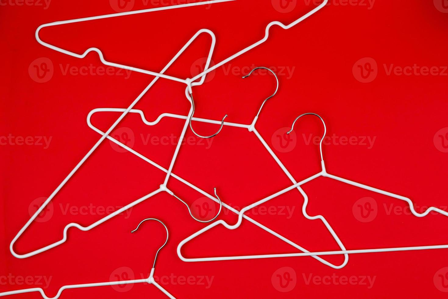 White clothes hangers on red background photo