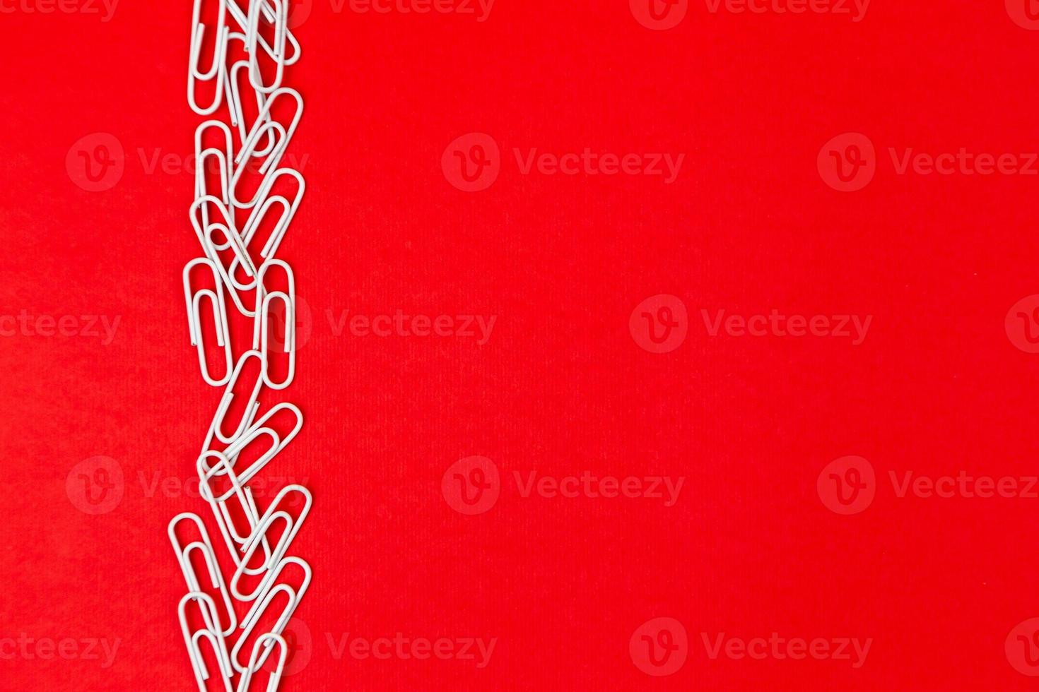 Close-up of white paper clips on a red background photo