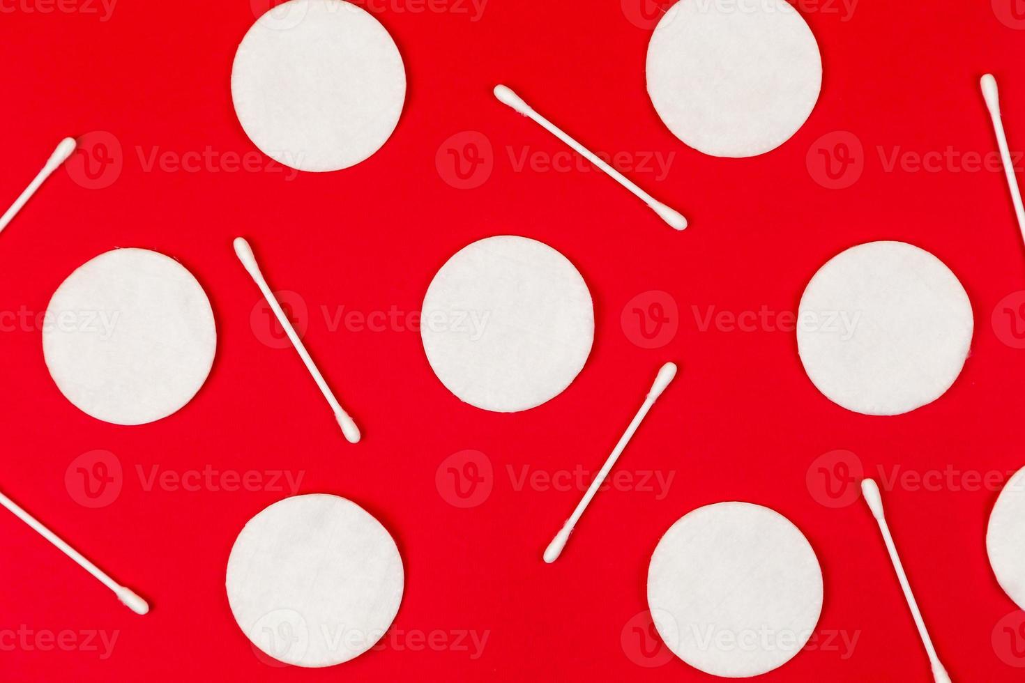 Background by cotton pads with ear sticks on red photo