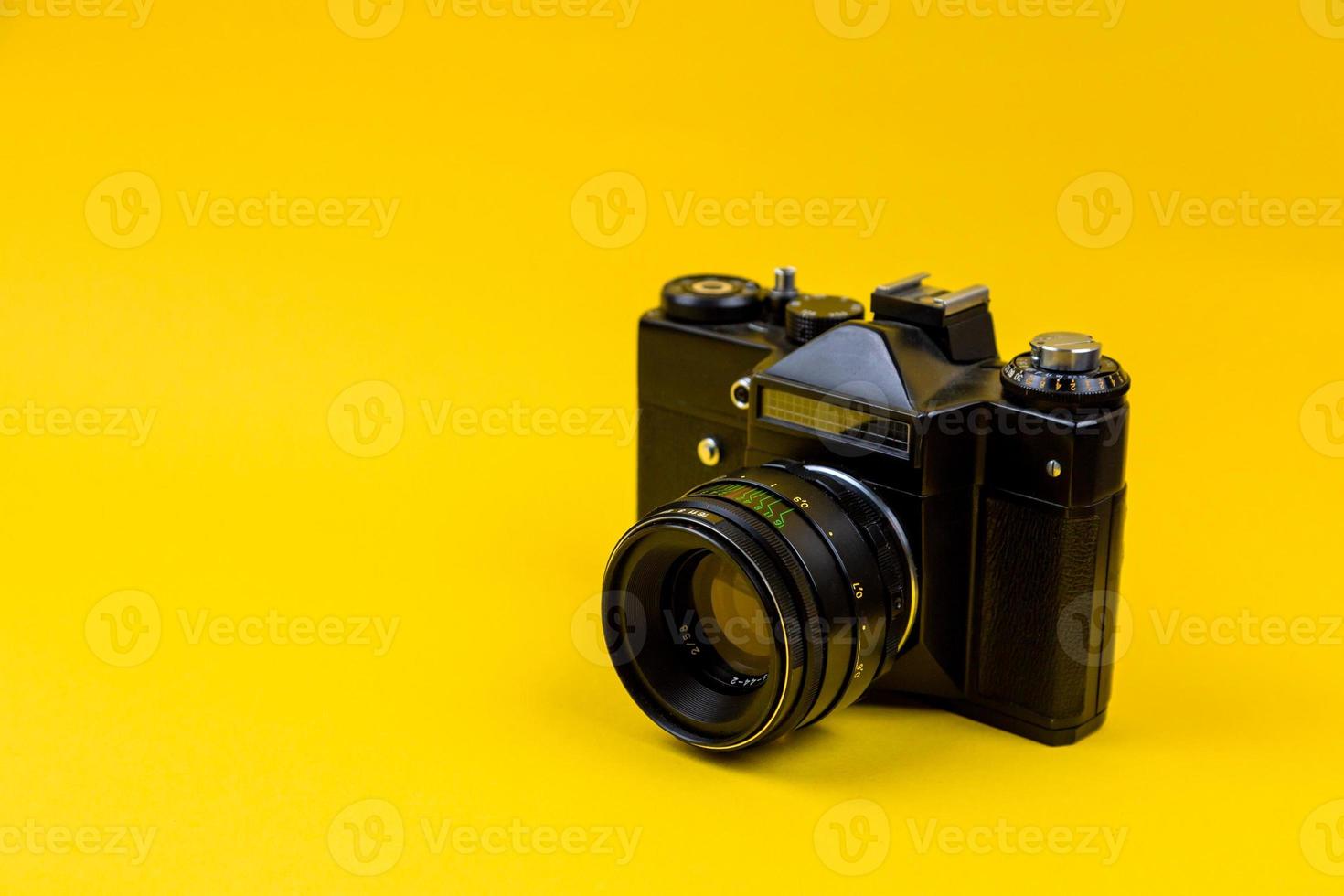 Flat lay film camera isolated on yellow background photo