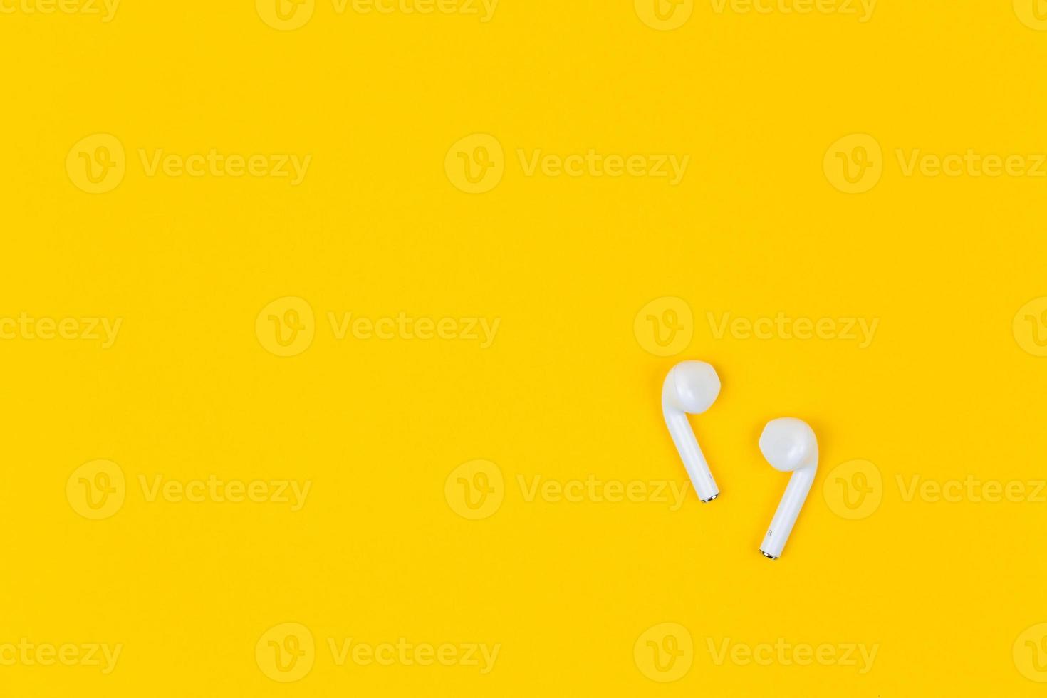White earphones on yellow background with copy space photo