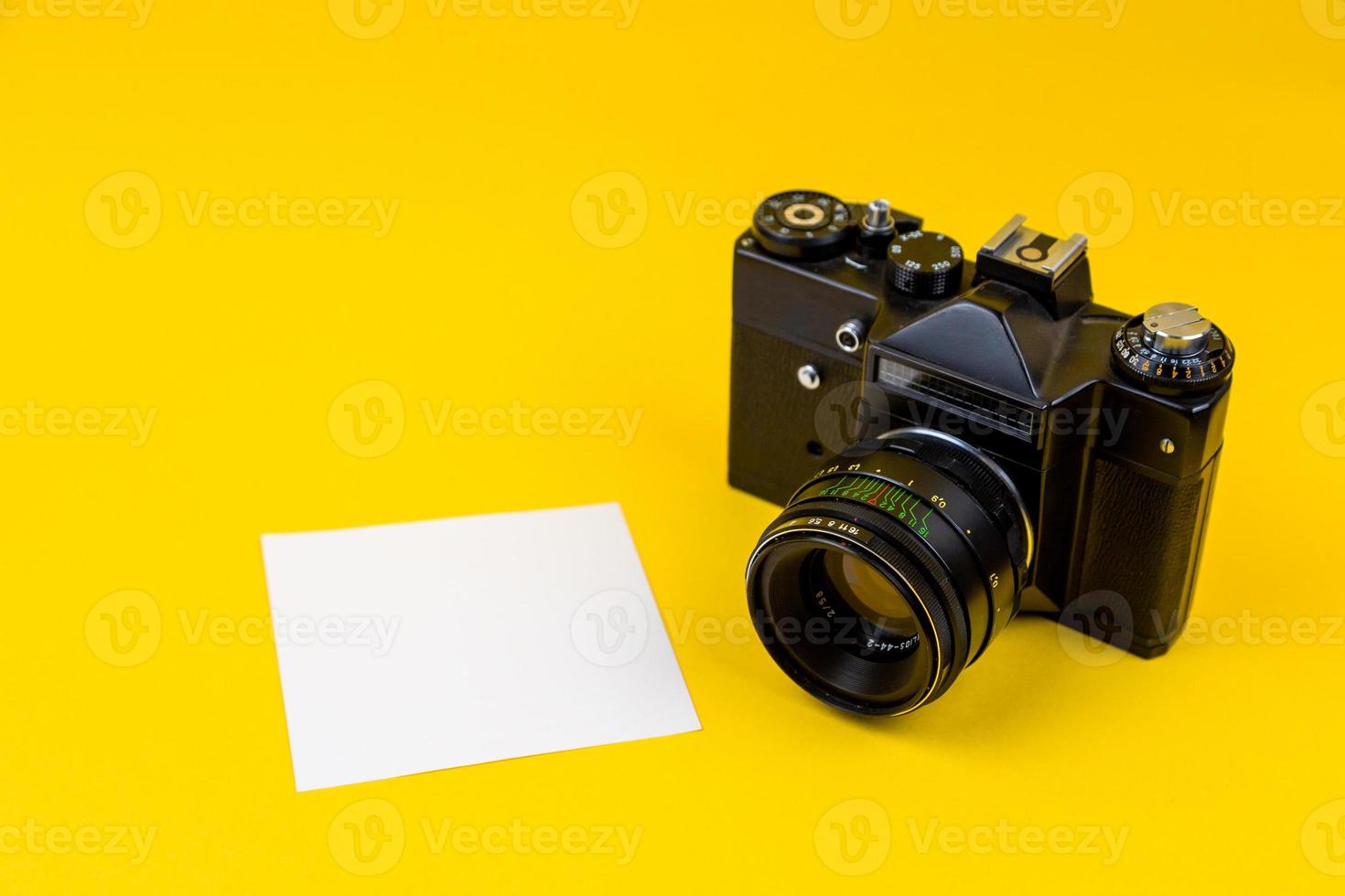 Flat lay film camera isolated on yellow background photo